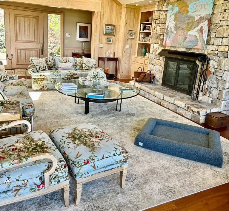 Interior of a home with a large, blue-colored orthopedic memory foam boucle dog bed.