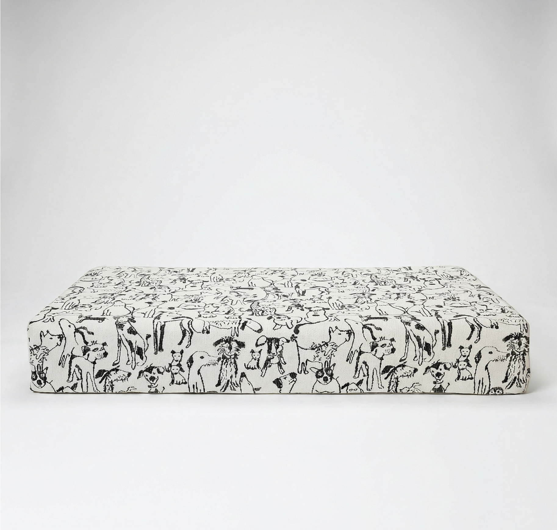 Dog lying on a patterned dog bed against a white background