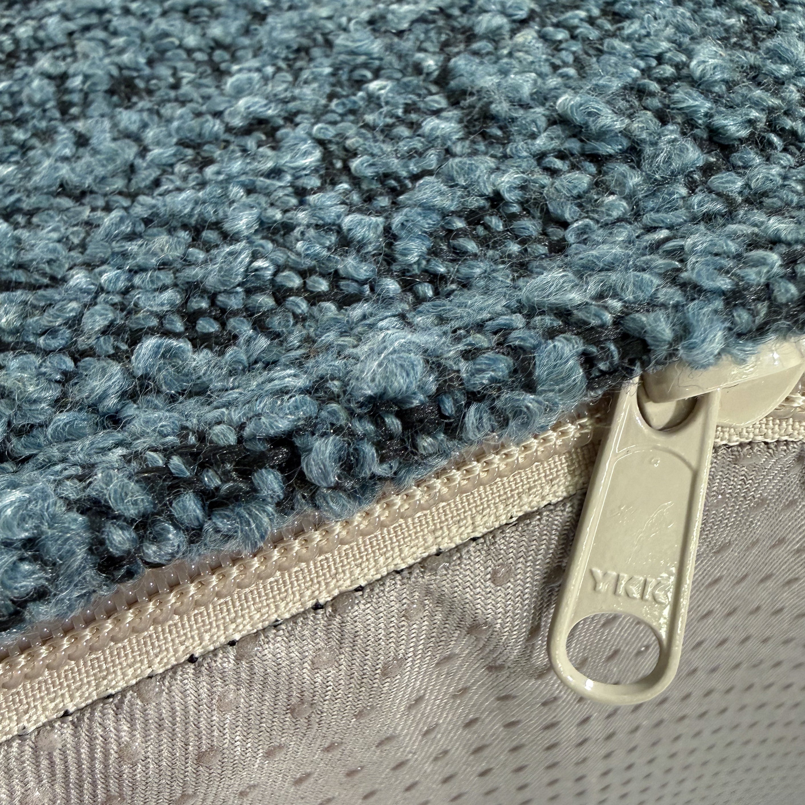 Up close of the YKK zipper on the ocean blue boucle dog bed.