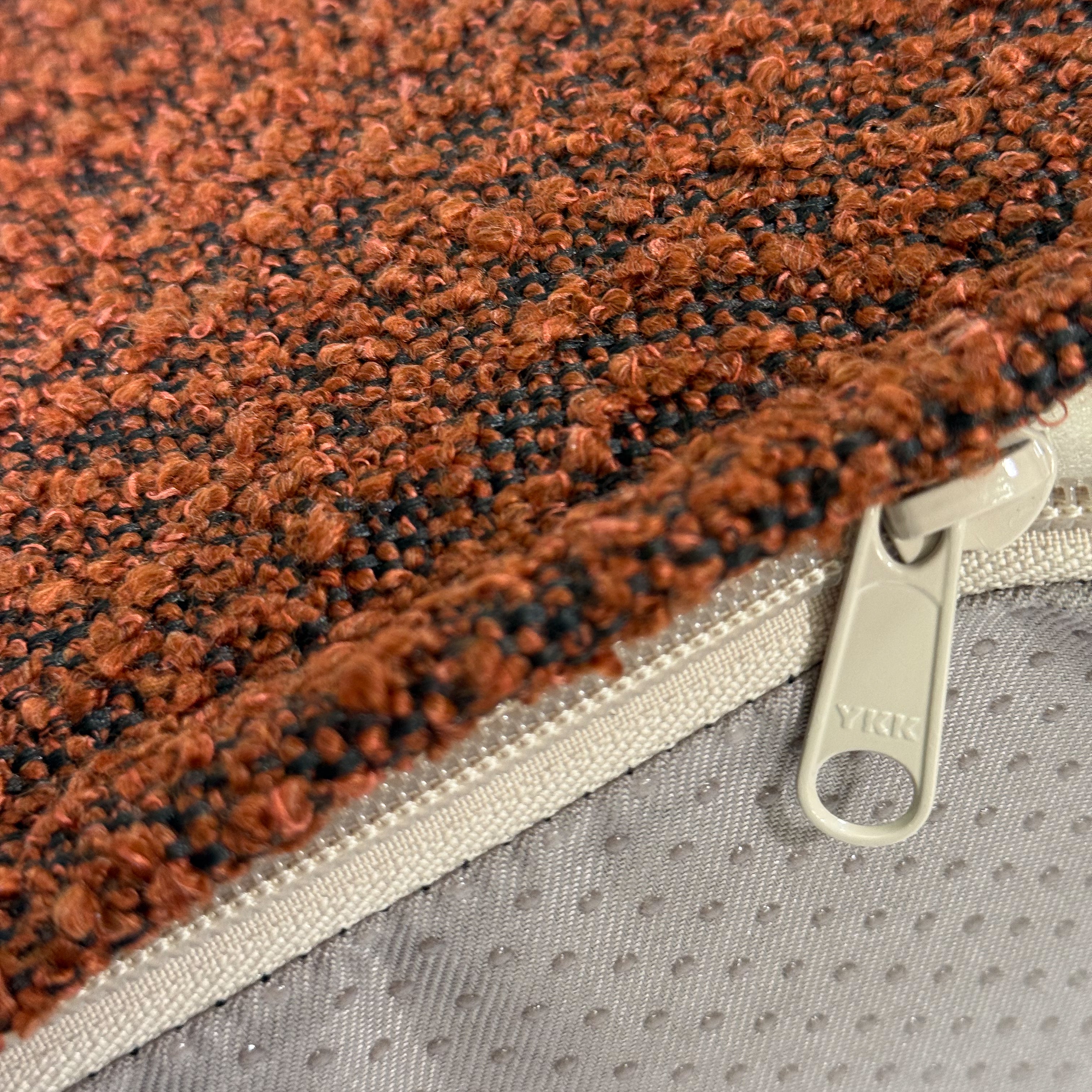 A close up of the pumpkin spice colored dog bed cover with YKK zipper.