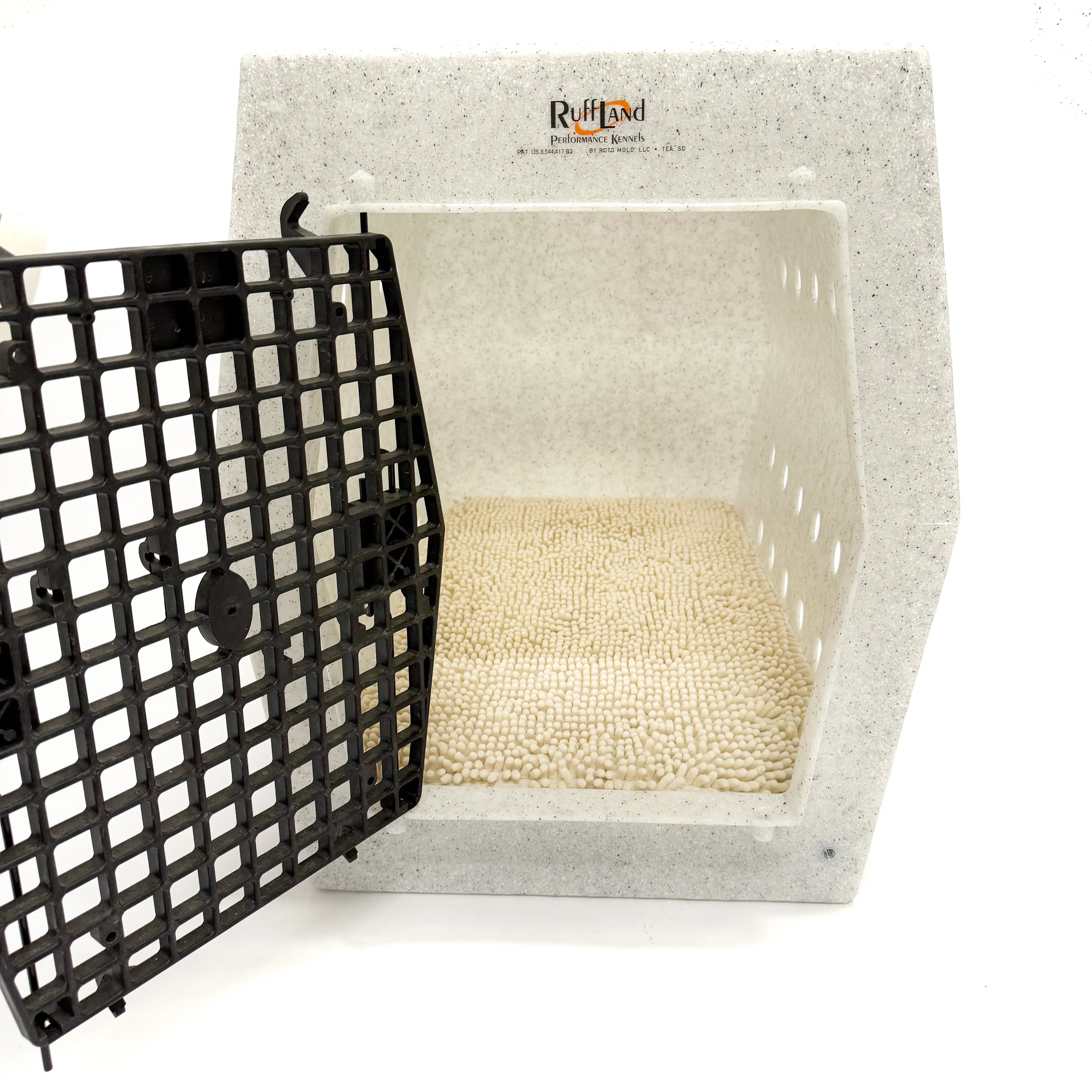 Crate pad with towel cover placed inside of a dog crate with door open on a white background.