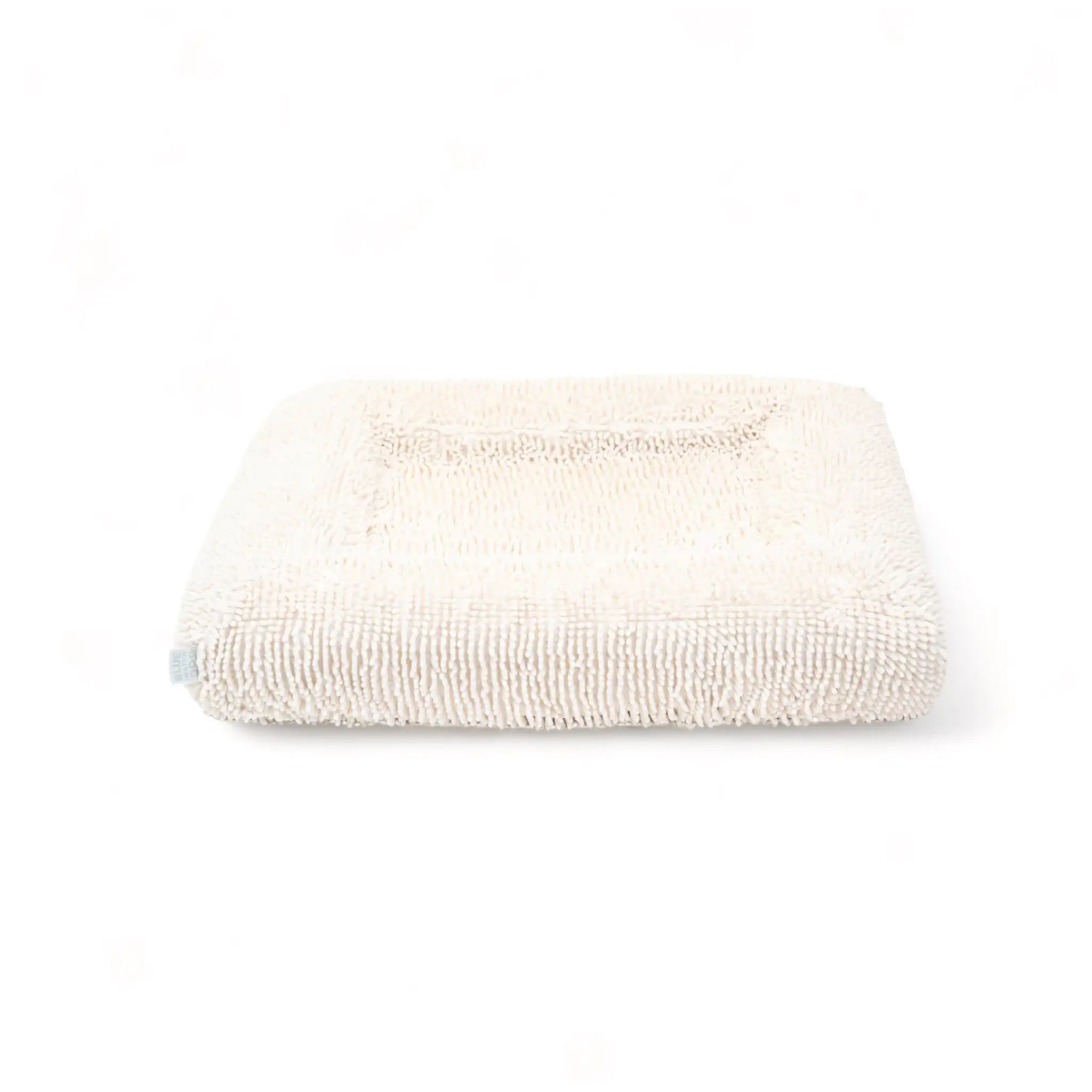 Front of a cream-colored shaggy towel cover on top of an orthopedic memory foam rectangular dog bed with bolsters.