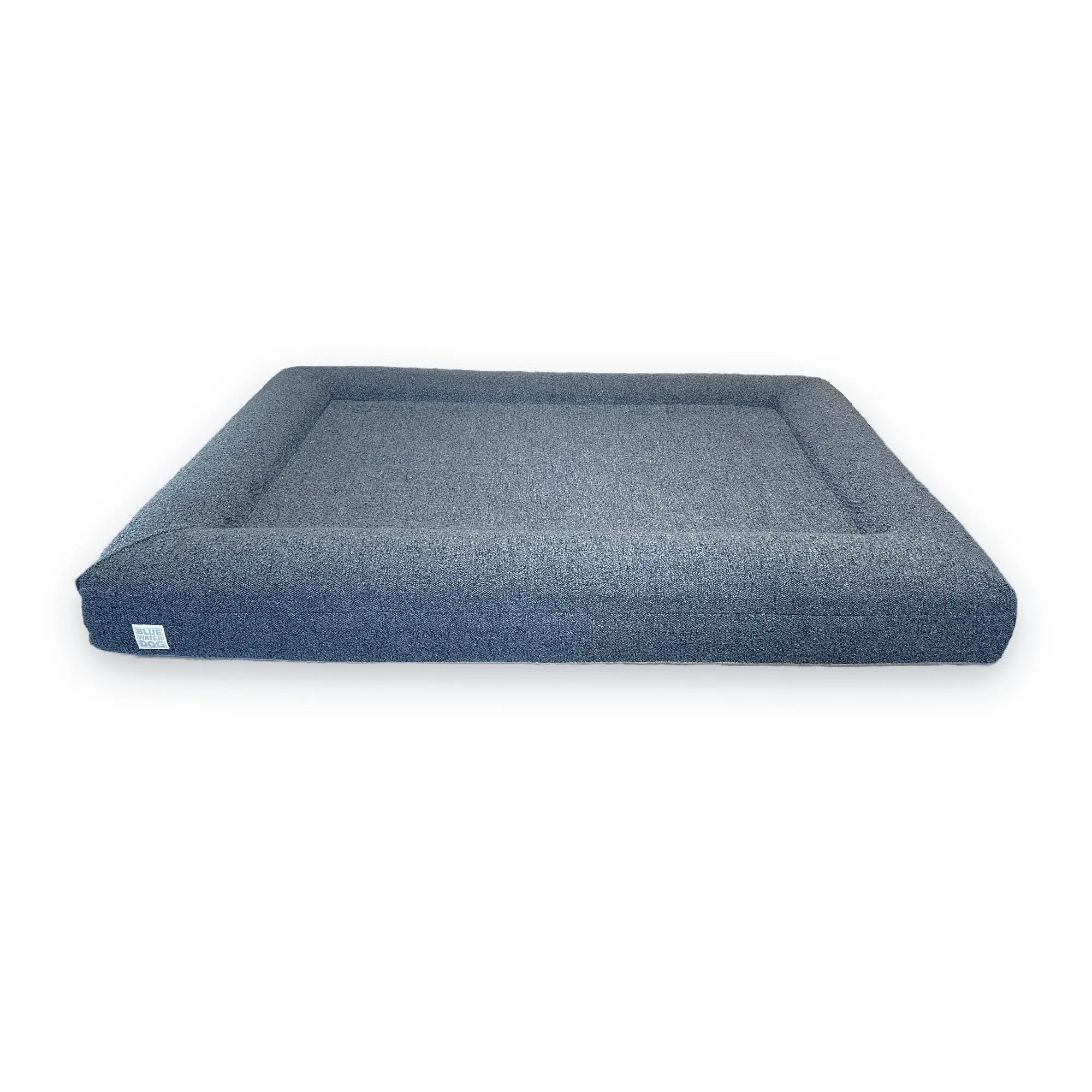 Front of an extra large, blue-colored orthopedic memory foam rectangular boucle dog bed with bolsters.