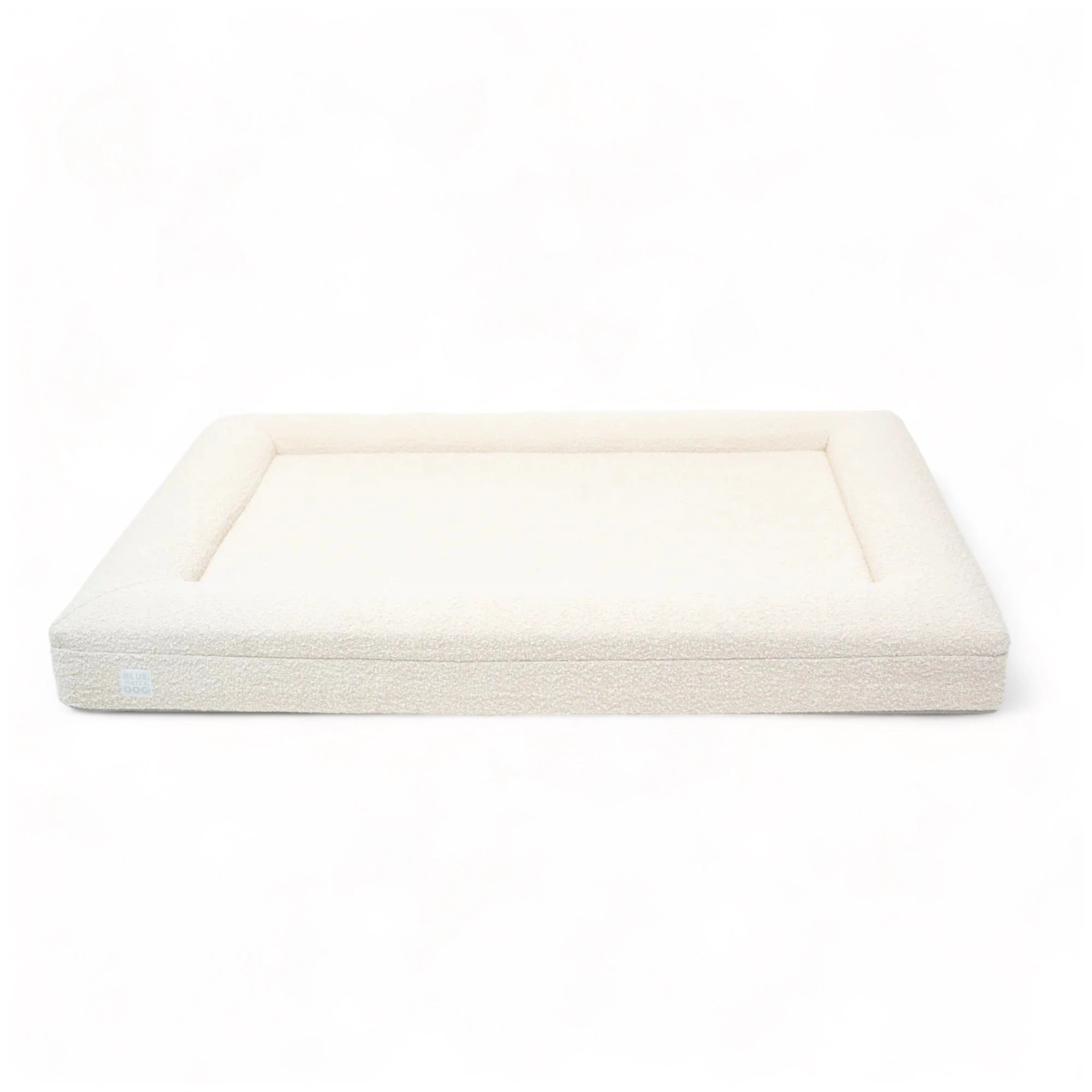 Front of an extra large, cloud-colored orthopedic memory foam rectangular boucle dog bed with bolsters.