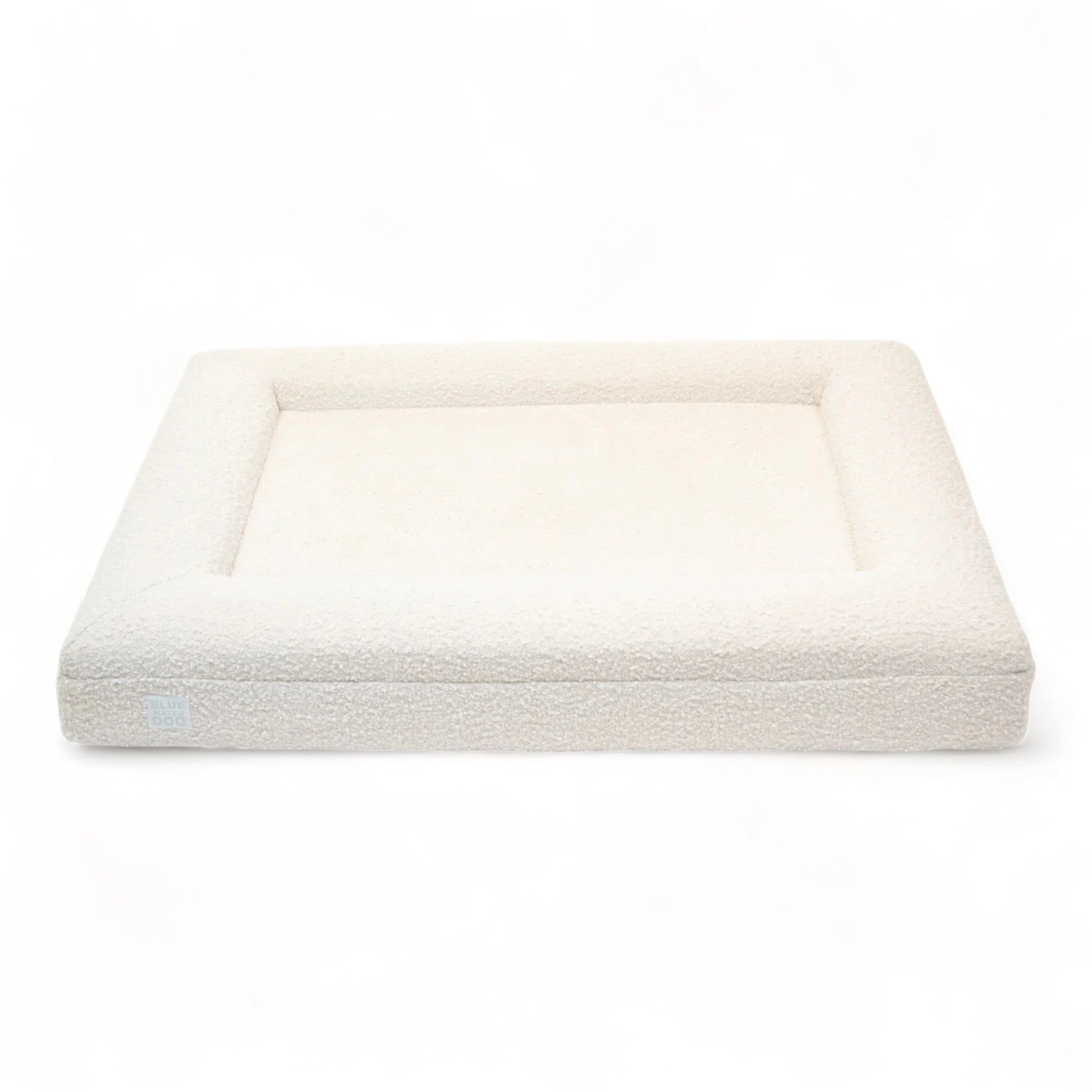 Front of a large, cloud-colored orthopedic memory foam rectangular boucle dog bed with bolsters.