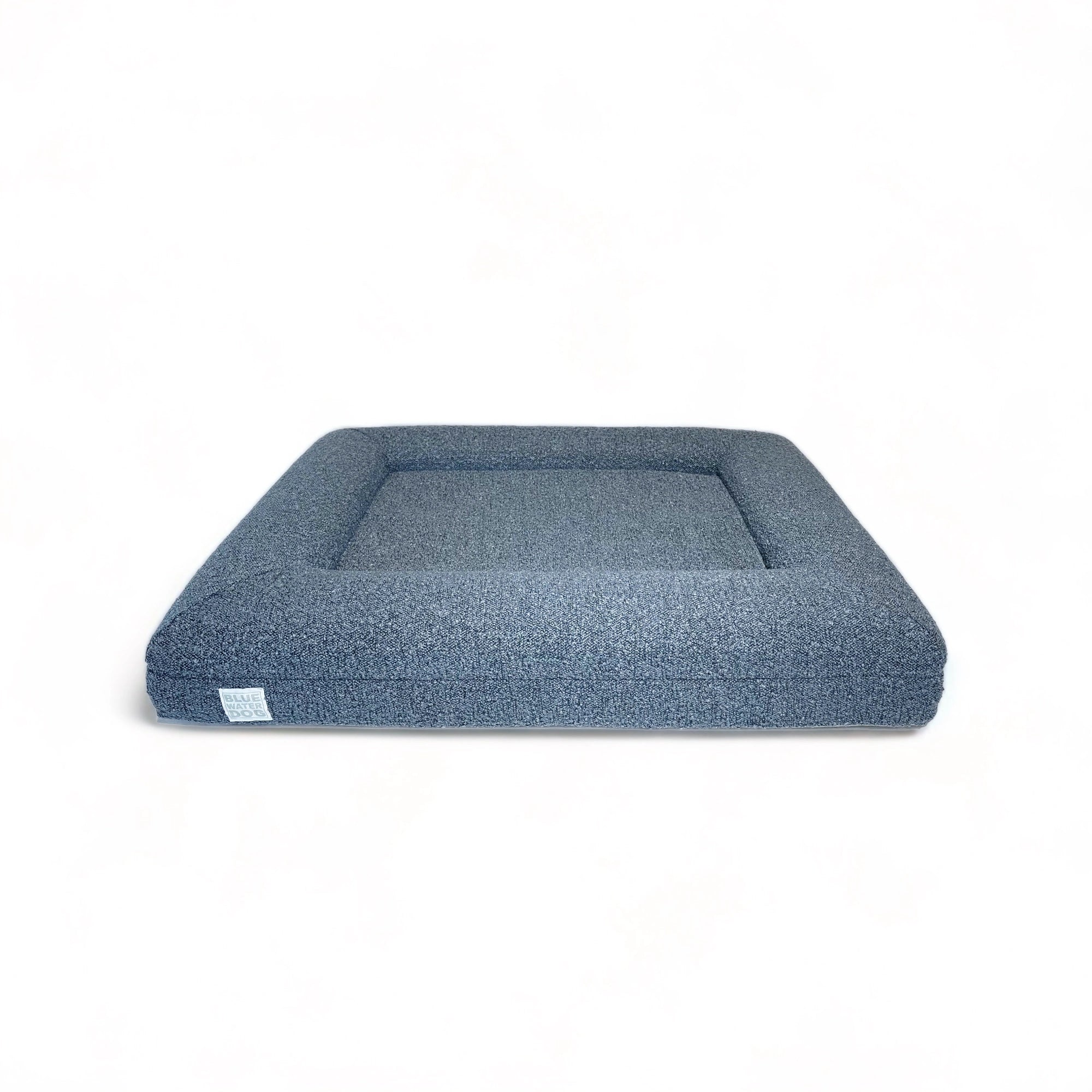Front of a medium, blue-colored orthopedic memory foam rectangular boucle dog bed with bolsters