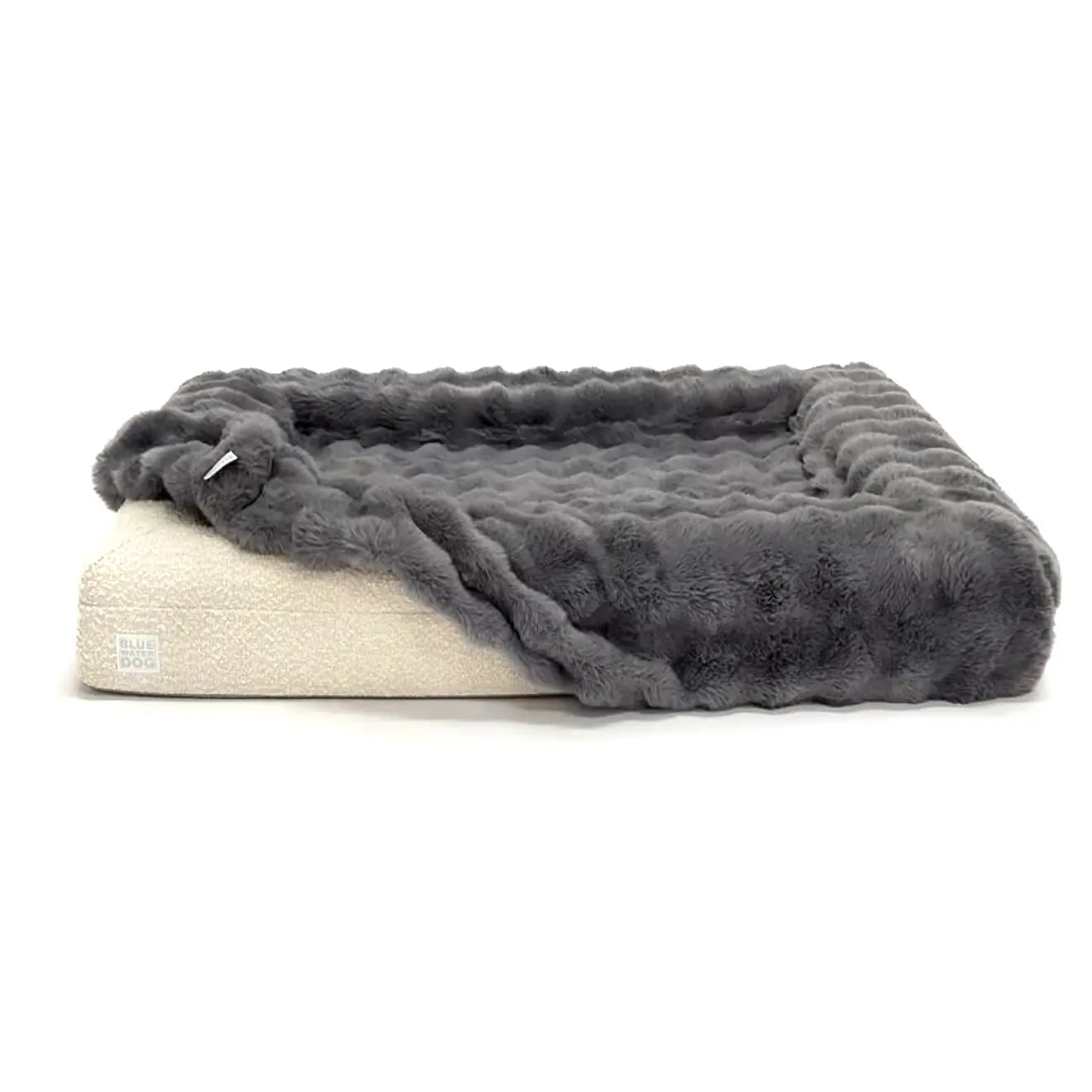 Dog bed with a gray faux fur cover on a white background