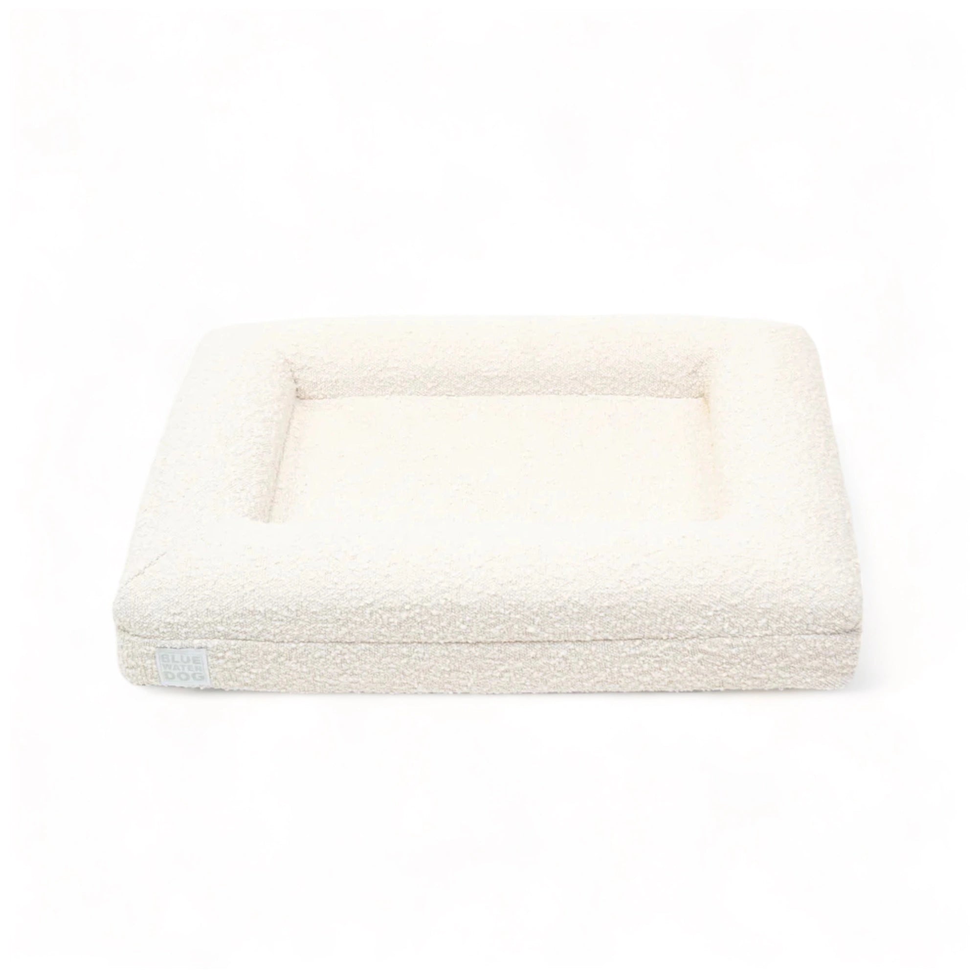 Front of a small, cloud-colored orthopedic memory foam rectangular boucle dog bed with bolsters